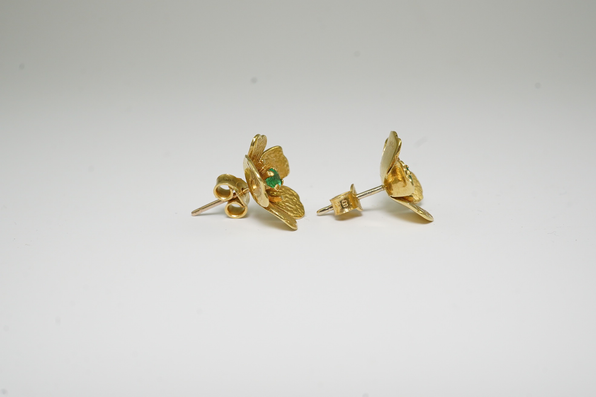 A pair of 1970's 18ct gold and single stone emerald set flower head earrings